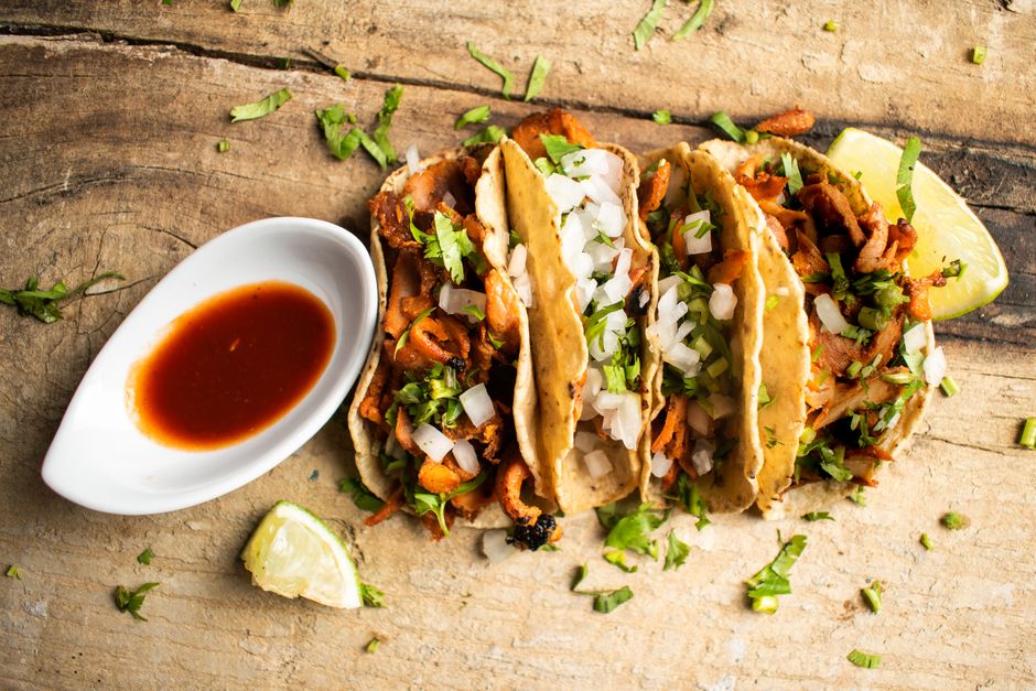 Street tacos topped with fresh onion, cilantro and salsa